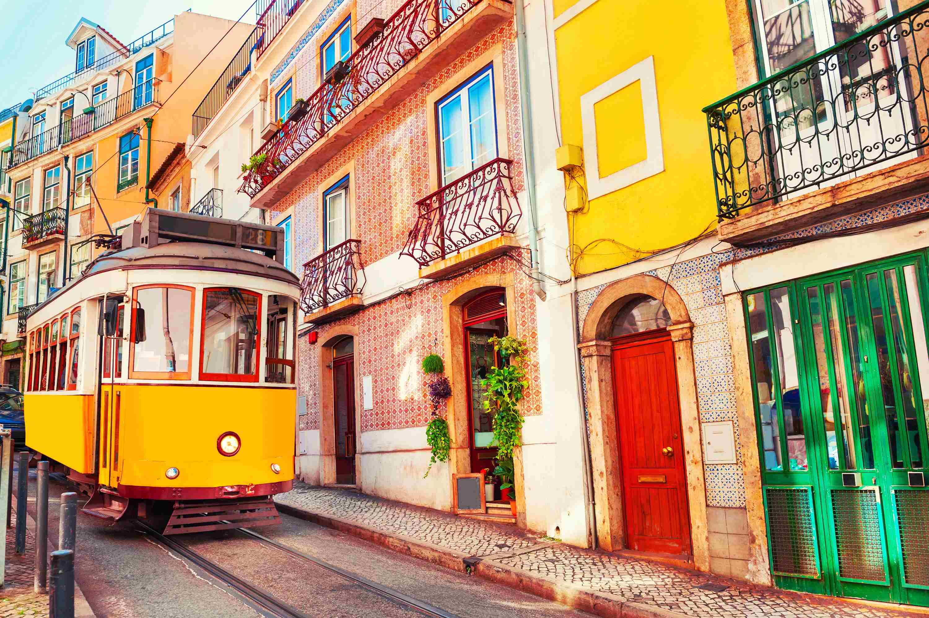 Yellow street tram on a colourful city street